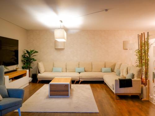 a living room with a couch and a table at Luxury 2BR Spacious & Stylish with Patio near Metro in Odivelas