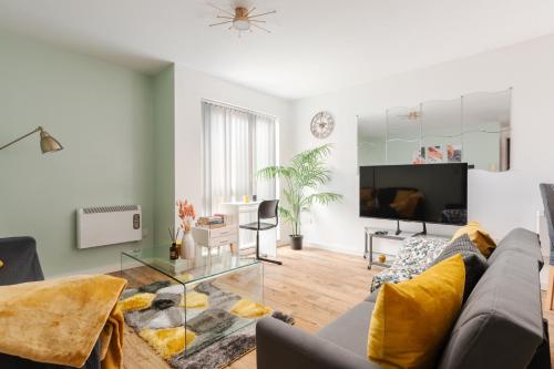 a living room with a couch and a tv at Beehive Salford Quays immaculate 1-Bed Flat with free-parking in Manchester