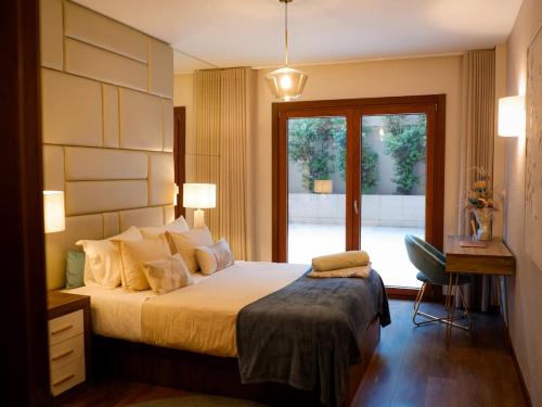 une chambre avec un lit, un bureau et une fenêtre dans l'établissement Luxury 2BR Spacious & Stylish with Patio near Metro, à Odivelas