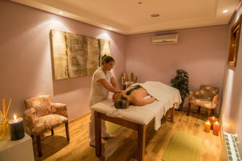 a woman in a hospital room with a patient on a bed at Hotel Recanto da Serra in Gramado