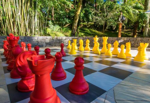 a giant chess board with red and yellow chess pieces at Hotel Recanto da Serra in Gramado