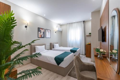 a hotel room with two beds and a tv at Seven Stays New Cairo in Cairo