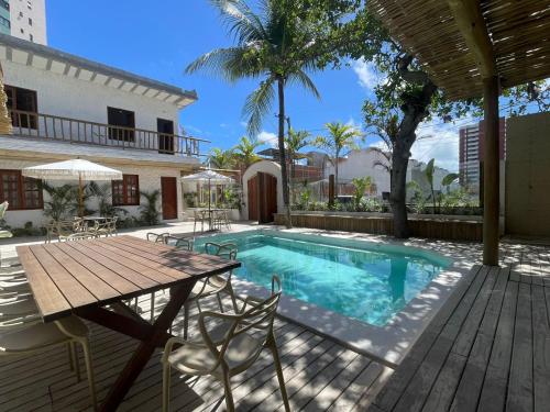 a patio with a table and a swimming pool at Villa da Praia -Orla de Atalaia in Aracaju