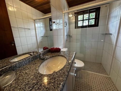 Un baño con lavabo e inodoro en Chalé Luxuoso Capivari em Campos do Jordão, en Campos do Jordão