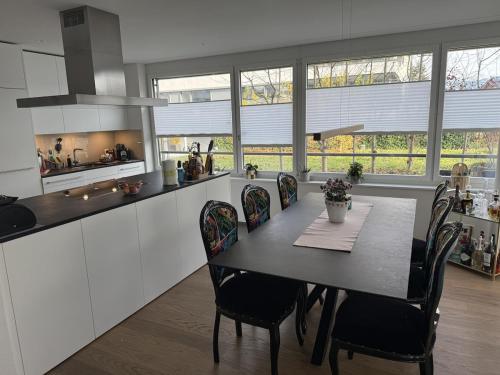 une cuisine avec une table et des chaises dans une pièce dans l'établissement Luxuriöse 3,5-Zimmer Wohnung für Familien und Geschäftsreisende mit Glasfaser-Internet, à Cham