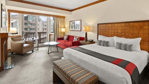 ein Hotelzimmer mit einem großen Bett und einem roten Sofa in der Unterkunft #337 Inside Lodge At Spruce Peak Studio Ski in in Ski out By Stowe Mountain Rentals in Stowe