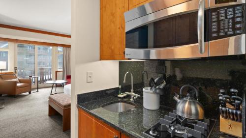 a kitchen with a sink and a microwave at 337 - Studio- Lodge At Spruce Peak -Stowe Mt Resort- Ski in Ski out - Sleeps 4 in Stowe