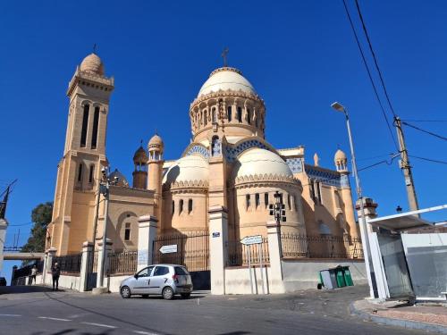 une voiture garée devant un immeuble avec une tour dans l'établissement Apartment 1, Family, Moorish Villa, à El Mouradia