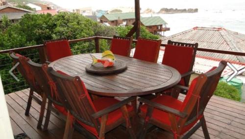 a wooden table with chairs and a bowl of fruit on it at TussenIn in Eersterivierstrand