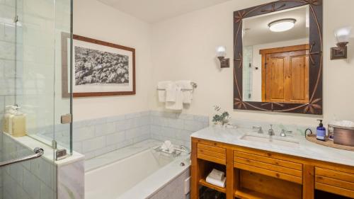 une salle de bain avec une baignoire, un lavabo et un miroir dans l'établissement 374 Lodge At Spruce Peak Ski In Ski In Ski Out King Studio By Stowe Mountain Rentals, à Stowe
