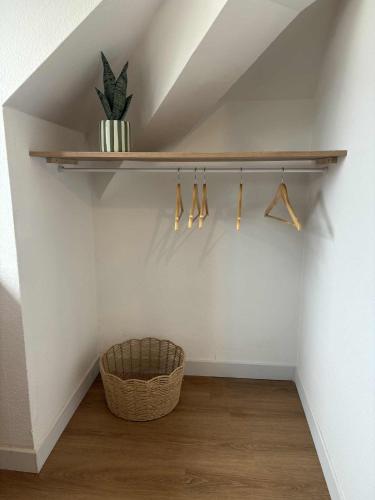 une pièce avec une étagère et un panier sur un mur dans l'établissement Charmant appartement - Le Dopamine, à La Roche-sur-Yon