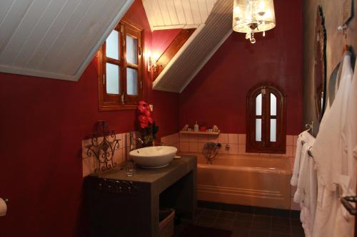 a red bathroom with a sink and a tub at Lokanga Boutique Hotel in Antananarivo