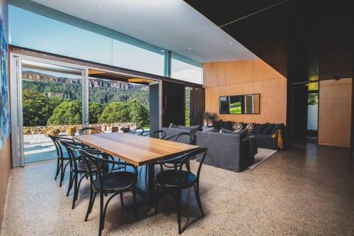 a dining room with a table and chairs and a couch at Willow at Barranca - Luxury Villa in Barrengarry