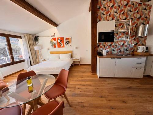 多尔切阿夸Il Nido - Guest house的一间卧室，里面有一张床、一张桌子和几把椅子。