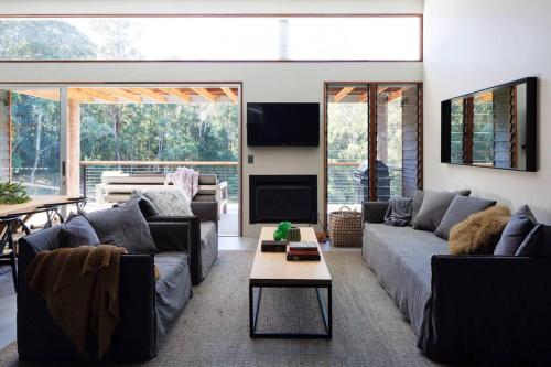 a living room with two couches and a table at Ferndale at Barranca - Luxury Villa in Barrengarry