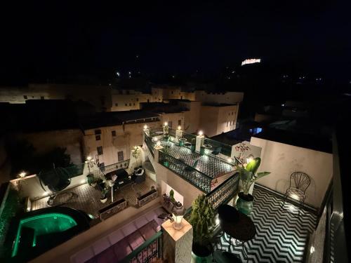 a view of a building with a swimming pool at night at Riad Dar El bellar in Fès