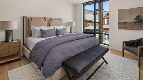 une chambre avec un grand lit et une chaise dans l'établissement Lux Mountainside 2 Bed Mountainside Condo By Stowe Mountain Rentals, à Stowe