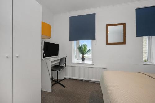 a bedroom with a bed and a desk and a television at Central MK Apartment 2 Bedrooms Free Parking Ideal for Contractors & Business Travellers in Milton Keynes