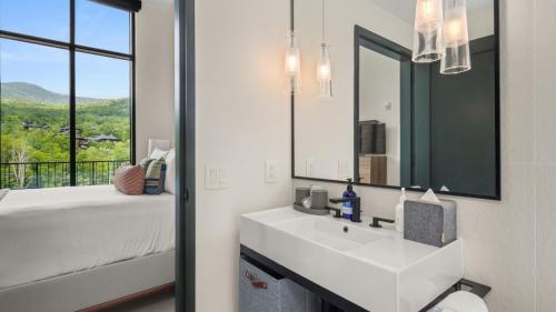 La salle de bains est pourvue d'un lavabo blanc et d'un grand miroir. dans l'établissement 409 3 bed Treehouse unit Spruce Peak at the Base of Stowe Mt Resort sleeps 9, à Stowe