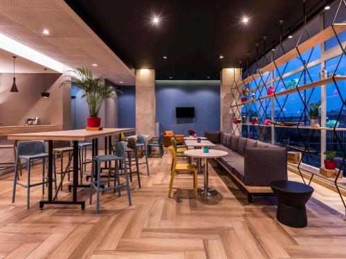 Un restaurante con mesas y sillas en una sala. en ibis Chia, en Chía