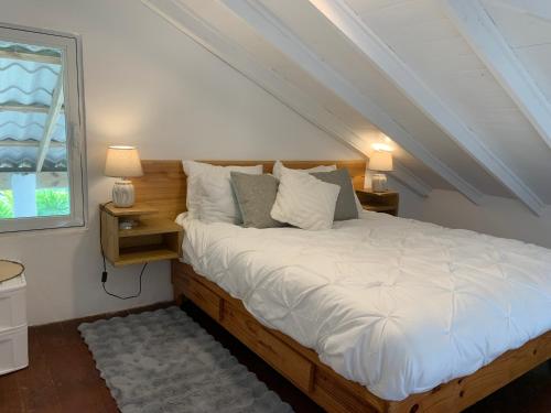 a bedroom with a bed with white sheets and a window at Villa Brisa del Caribe in Las Terrenas