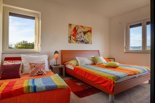 two beds in a room with two windows at Apartman Kačić in Sveti Ivan Dobrinjski