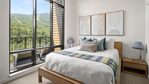 une chambre avec un grand lit et une grande fenêtre dans l'établissement Stowe Mt Resort Treehouse Ski in Ski Out Mt Views By Stowe Mountain Rentals, à Stowe