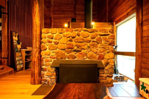 a stone fireplace in a room with a stone wall at みみずく山荘 Mimizuku Lodge in Myoko