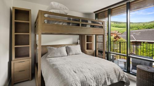 une chambre avec un lit superposé et une grande fenêtre dans l'établissement 420 Lodge At Spruce Peak New Treehouse Unit 3 bed Sleeps 10, à Stowe
