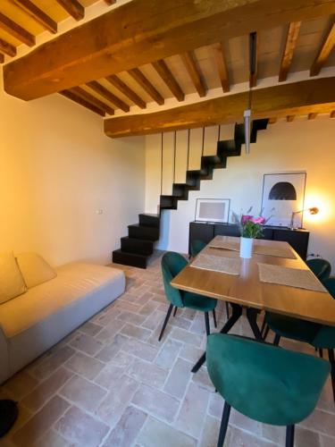a dining room with a table and green chairs at Villa Angela - Ranza 55 in Lugnano