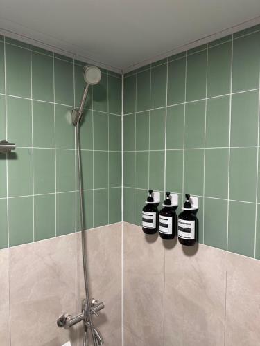 tres botellas de jabón en un baño con azulejos verdes en 부일파크, en Suwon
