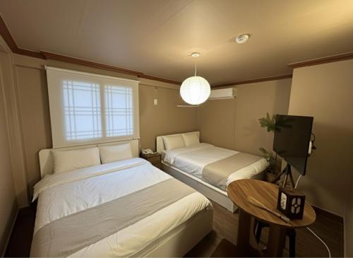 Una habitación con dos camas y una mesa y un televisor. en 부일파크, en Suwon