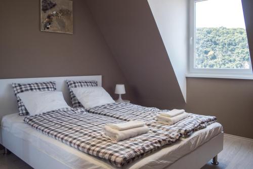 a bed with two pillows on it with a window at Flat with Unforgettable View in Budapest