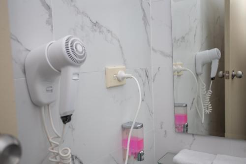 ein Badezimmer mit Föhn und Spiegel in der Unterkunft Westside Motor Inn in Sydney