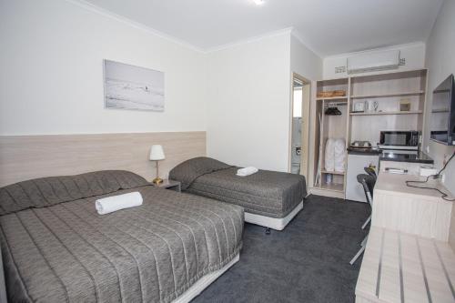 a hotel room with two beds and a kitchen at Westside Motor Inn in Sydney