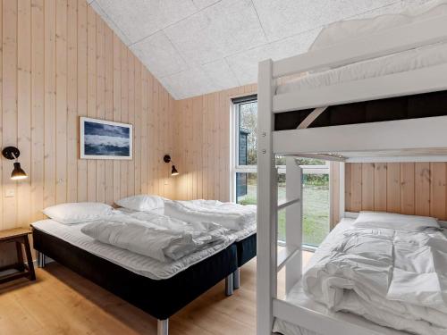 une chambre avec deux lits superposés et une fenêtre dans l'établissement 5 star holiday home in Idestrup, à Bøtø By