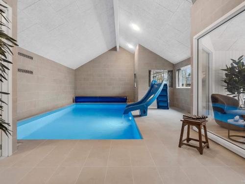une piscine avec toboggan dans une maison dans l'établissement 5 star holiday home in Idestrup, à Bøtø By
