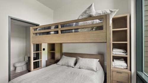 une chambre avec un lit superposé en bois avec des toilettes dans l'établissement Stowe Mt Resort Spruce Peak 4 Bed Treehouse Condo By Stowe Mountain Rentals, à Stowe
