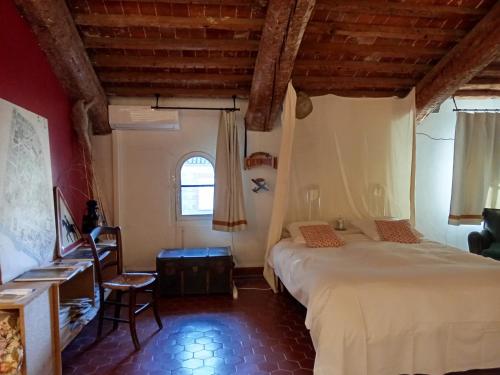 a bedroom with a bed and a desk and a window at Le Mas Palegry Chambres d'hôtes Perpignan in Perpignan
