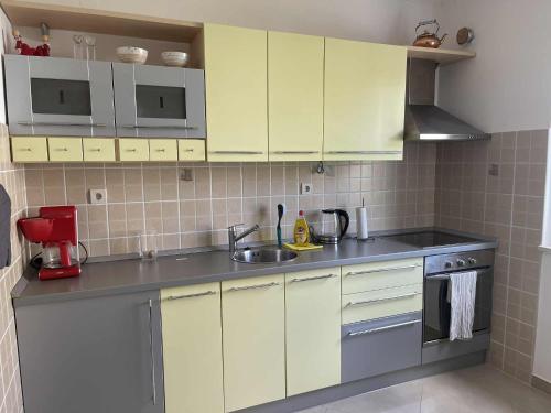 伊加洛Igalo Montenegro - Nice apartment 20 m from the sea!的带白色橱柜和水槽的厨房