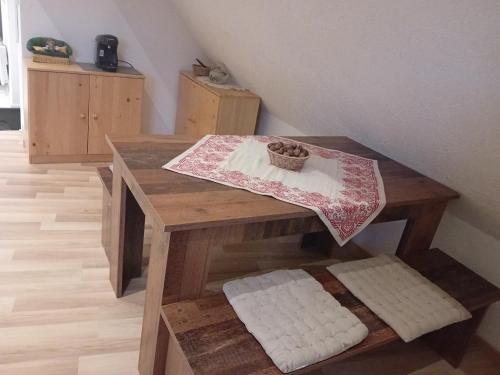 einen Holztisch mit einem Korb darüber in der Unterkunft Appartement T2 44 m2 in Kesseldorf