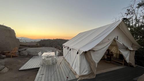 ein großes weißes Zelt auf einer Holzterrasse in der Unterkunft Cozy Mountain View Glamping Tent in De Luz Heights