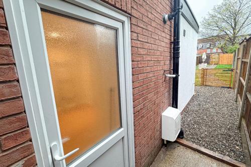 a glass door to a brick building with at Cosy Stay Near Safari Park, Bewdley & Wyre Forest in Kidderminster