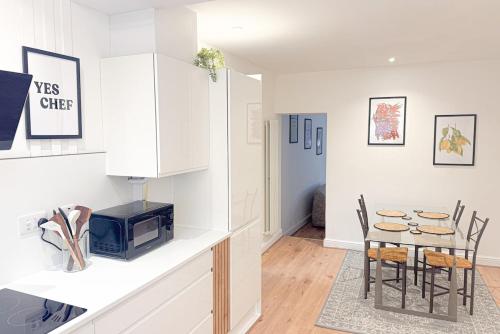 a kitchen and dining room with a table and a microwave at Cosy Stay Near Safari Park, Bewdley & Wyre Forest in Kidderminster