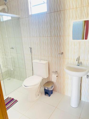 a bathroom with a toilet and a sink at Pousada Rio e Mar in Fortim