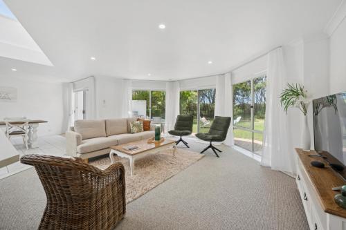 a living room with a couch and a table and chairs at Beachfront Retreat - Ducted Air - Free Wifi in Coffs Harbour