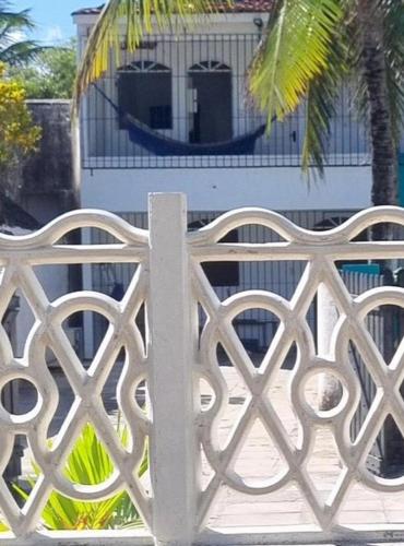 une clôture en métal blanc avec un hamac en arrière-plan dans l'établissement Casabeiramaritamaracá, à Itamaracá