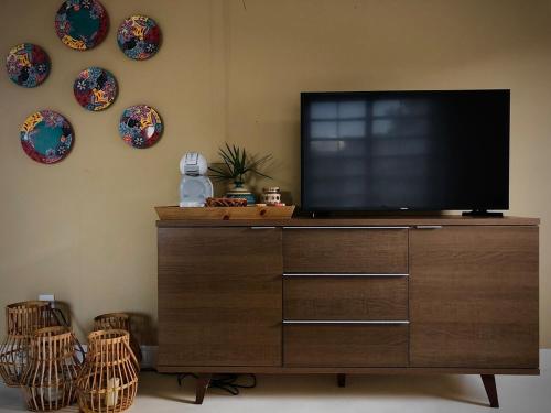 Ein Fernseher auf einer Kommode, Teller an der Wand. in der Unterkunft Casa nova ideal para familia in Cavalcante