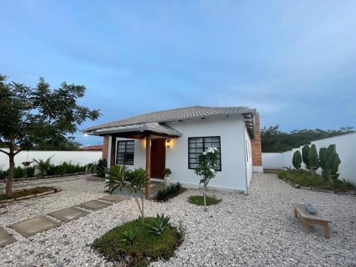 ein kleines weißes Haus mit einer Bank in einem Hof in der Unterkunft Casa nova ideal para familia in Cavalcante