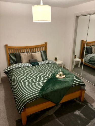 a bedroom with a bed with a black and white comforter at Tartan Nest- Entire house- Sleeps 8 guests in Mansewood